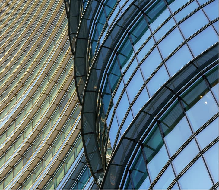 Curved glass skyscraper facade reflecting sunlight