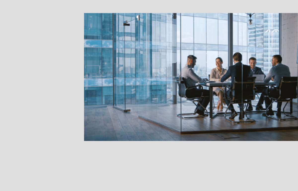 Advisory team collaborating in a glass-walled conference room