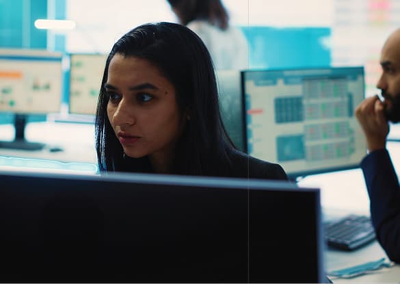 Cybersecurity analyst reviewing monitors