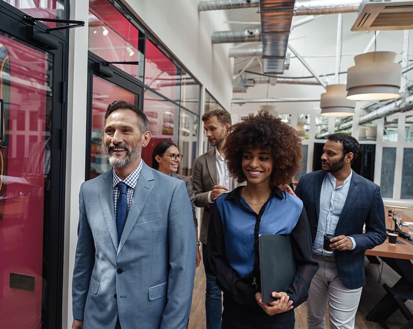 Diverse professionals walking through a modern workplace